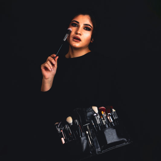 a woman with makeup brushes in her hand